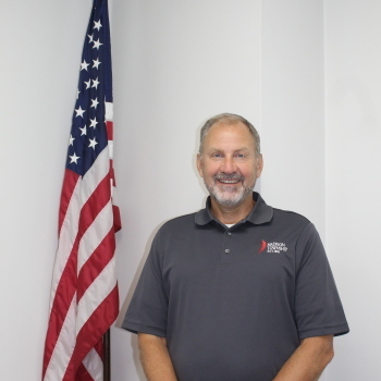 Jeff Willoughby standing next to flag